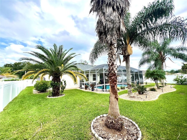 view of yard with glass enclosure and a fenced in pool