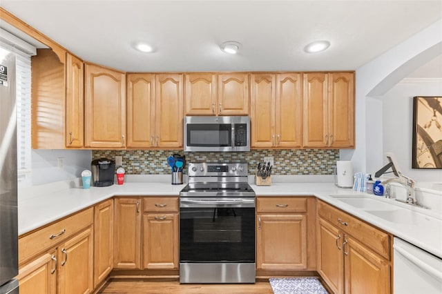 kitchen featuring light hardwood / wood-style floors, appliances with stainless steel finishes, backsplash, and sink