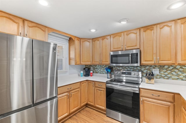 kitchen featuring light brown cabinets, light hardwood / wood-style floors, appliances with stainless steel finishes, and tasteful backsplash