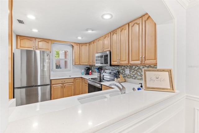 kitchen with stainless steel appliances, light brown cabinetry, tasteful backsplash, and sink