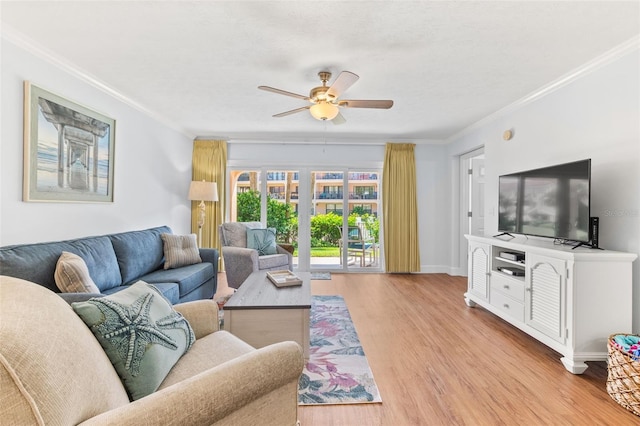 living room with crown molding, ceiling fan, and light hardwood / wood-style flooring