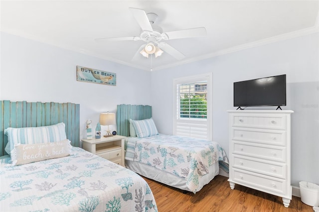 bedroom with ceiling fan, crown molding, and wood-type flooring