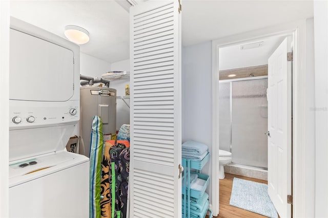 washroom with stacked washer and dryer and light hardwood / wood-style floors