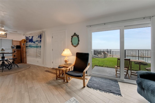 interior space featuring ceiling fan, a water view, and light hardwood / wood-style floors