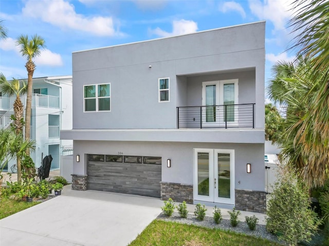 view of front of house featuring a balcony, french doors, and a garage