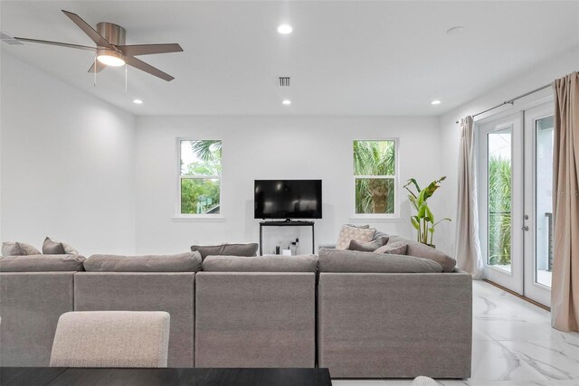 living room with a healthy amount of sunlight, ceiling fan, and french doors