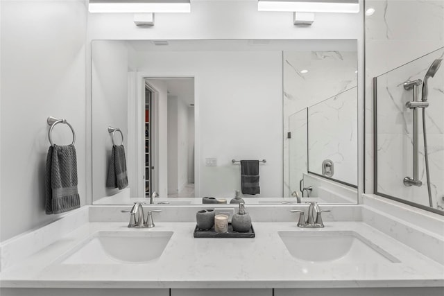 bathroom featuring a tile shower and vanity