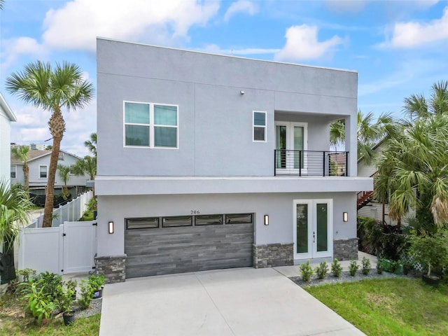 modern home featuring a balcony, french doors, and a garage