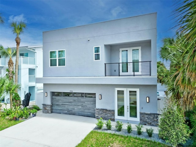 contemporary home featuring a balcony, a garage, and french doors