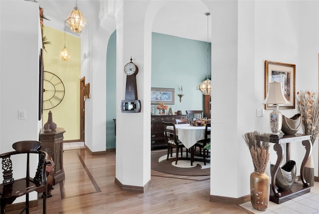 hall with light hardwood / wood-style flooring and a high ceiling