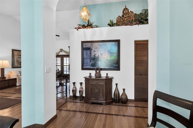 interior space with a towering ceiling and hardwood / wood-style floors