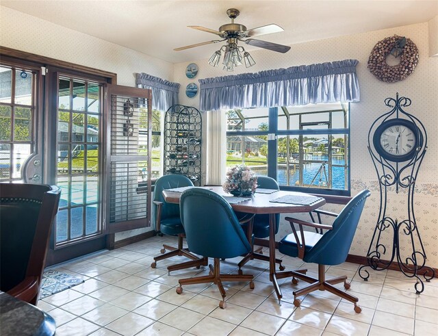 tiled dining space featuring a water view and ceiling fan