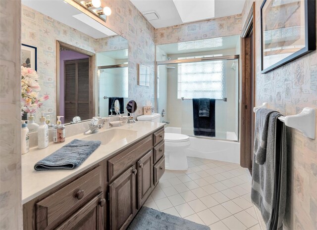 full bathroom with vanity, tile patterned floors, toilet, and combined bath / shower with glass door