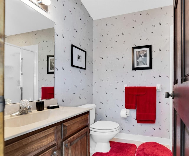 bathroom featuring vanity, toilet, and a shower with shower door