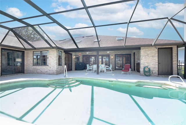 view of swimming pool featuring a lanai and a patio