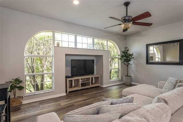 living room with a healthy amount of sunlight, dark hardwood / wood-style floors, and ceiling fan