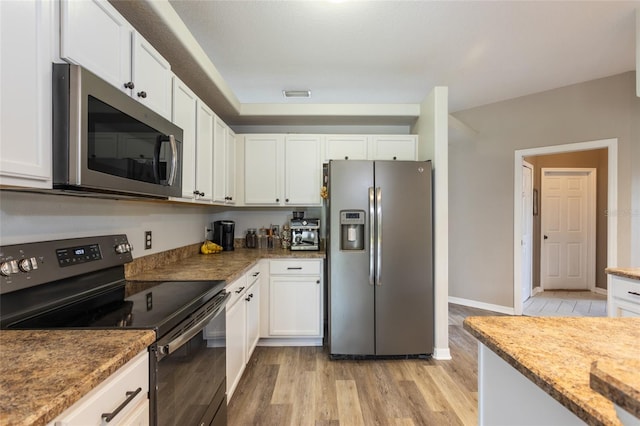 kitchen with stone countertops, appliances with stainless steel finishes, white cabinetry, and light hardwood / wood-style flooring