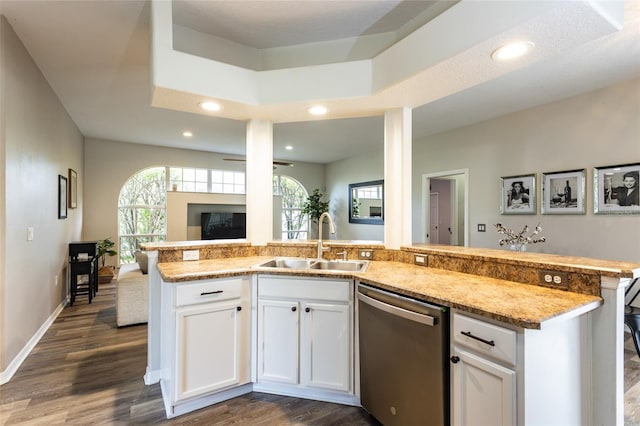 kitchen with dark wood-type flooring, white cabinets, light stone countertops, stainless steel dishwasher, and sink