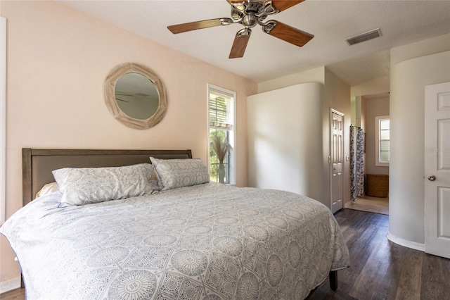 bedroom featuring connected bathroom, dark hardwood / wood-style floors, and ceiling fan