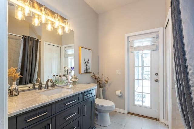 bathroom featuring tile patterned flooring, vanity, and toilet