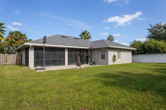 back of house featuring a sunroom, a lawn, and a patio