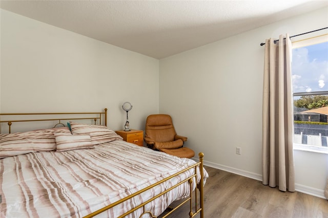 bedroom with light hardwood / wood-style floors and a textured ceiling