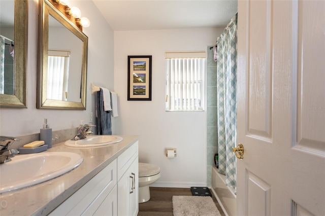 full bathroom with vanity, shower / bath combo, hardwood / wood-style flooring, and toilet