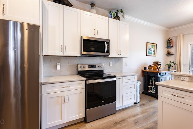 30 Front St, Palm Coast, FL 32137 - kitchen featuring stainless steel appliances, crown molding, light countertops, white cabinetry, and decorative backsplash