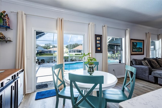 dining space featuring light hardwood / wood-style flooring and crown molding