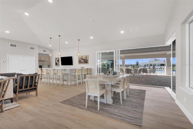 dining room featuring vaulted ceiling and light wood-type flooring