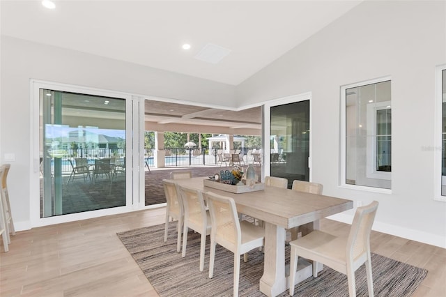 dining area featuring light wood-type flooring and lofted ceiling