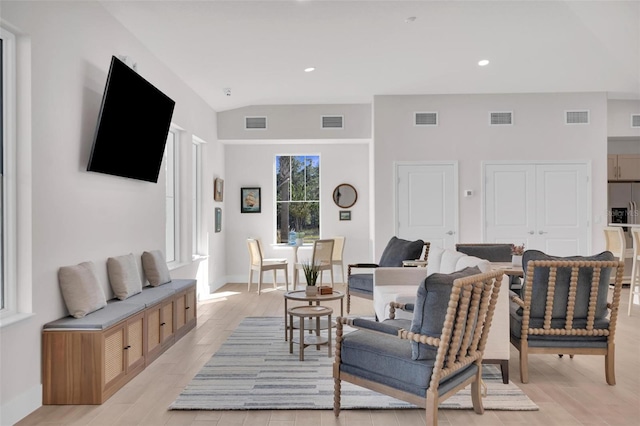 living room with light wood-type flooring and vaulted ceiling