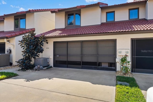 mediterranean / spanish home featuring a garage and central AC