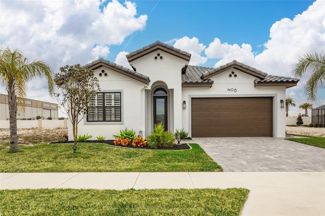 mediterranean / spanish-style house featuring a front yard and a garage