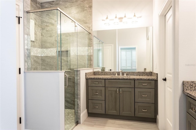 bathroom with wood-type flooring, vanity, and walk in shower