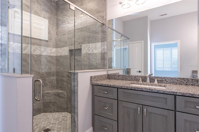 bathroom featuring vanity and a shower with shower door