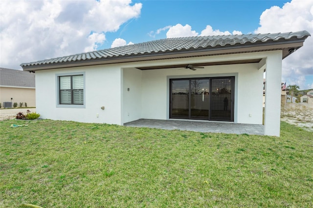 rear view of property featuring a patio, ceiling fan, and a lawn