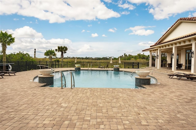 view of pool featuring pool water feature and a patio