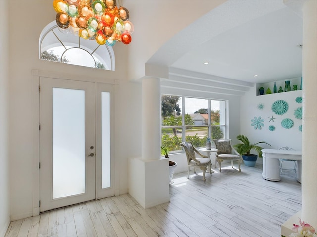 entrance foyer featuring an inviting chandelier, light hardwood / wood-style floors, and a high ceiling