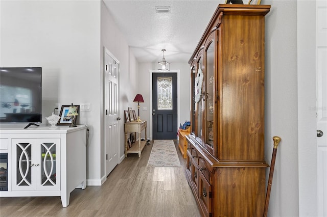 entryway featuring a textured ceiling and light hardwood / wood-style floors