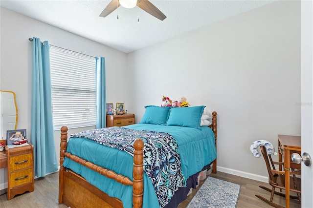 bedroom with a textured ceiling, hardwood / wood-style floors, and ceiling fan