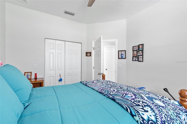 bedroom with a closet, ceiling fan, and a textured ceiling