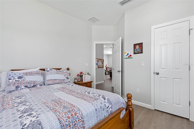 bedroom with a textured ceiling and hardwood / wood-style floors