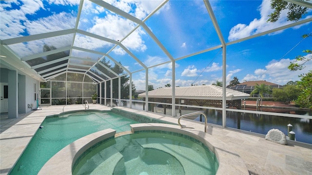 view of pool featuring an in ground hot tub, a water view, glass enclosure, and a patio