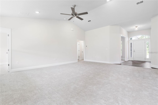 unfurnished living room featuring lofted ceiling, dark carpet, and ceiling fan