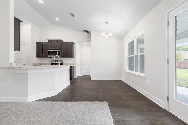 kitchen with dark hardwood / wood-style floors, vaulted ceiling, an inviting chandelier, and decorative light fixtures