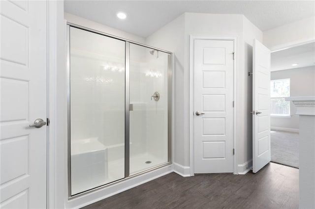 bathroom featuring hardwood / wood-style flooring and an enclosed shower