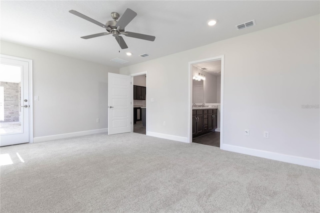 interior space featuring ceiling fan, ensuite bathroom, and carpet floors