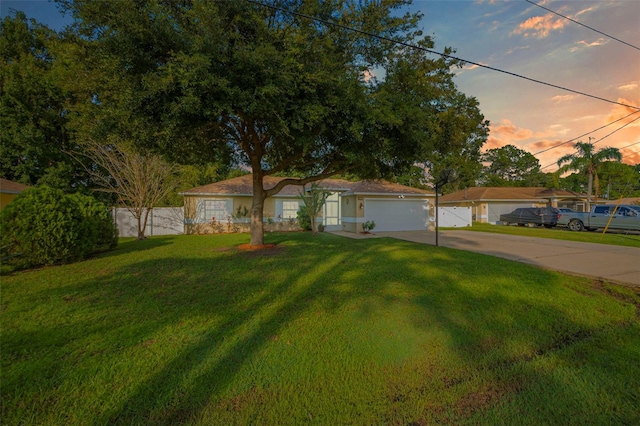 view of front of home featuring a garage and a lawn