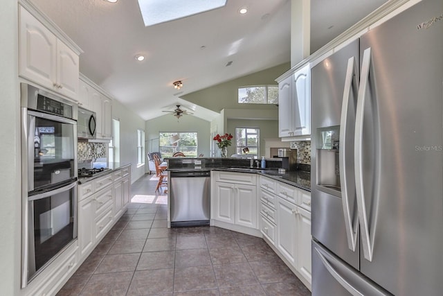 12 S Lakewalk Dr, Palm Coast, FL 32137 - kitchen featuring stainless steel appliances, a peninsula, lofted ceiling, white cabinets, and dark tile patterned flooring